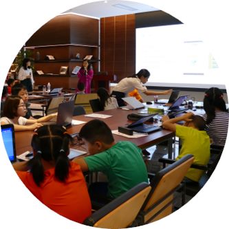 学生围坐长桌使用电脑参与课堂学习