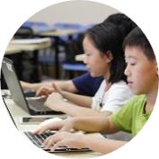两名学生并坐使用笔记本电脑